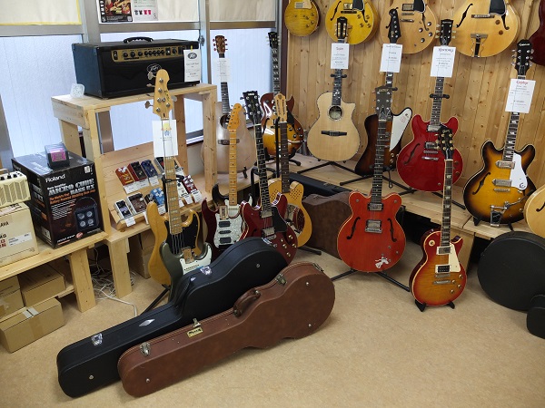 お店の角っこには見メンテのギターたちとお気場所からあふれてしまったハードケース。
